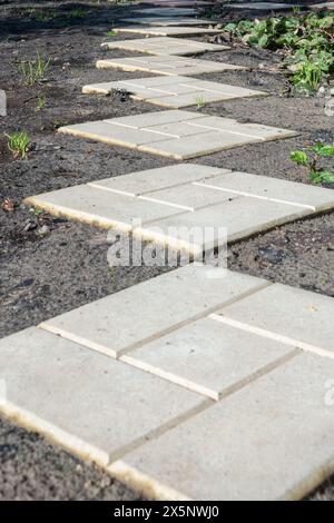 Perspektive von Betonpflasterplatten auf dem Gartengrundstück des Landhauses. Hüttengarten. Stockfoto