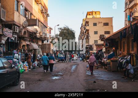 Eine belebte Straße mit verschiedenen Verkaufsständen, die Lebensmittel und Kleidung in der Stadt Assuan, Ägypten, verkaufen Stockfoto