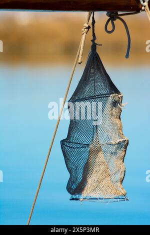Handgefertigte Angelausrüstung, die am Vorsegel eines Fischerbootes hängt Stockfoto