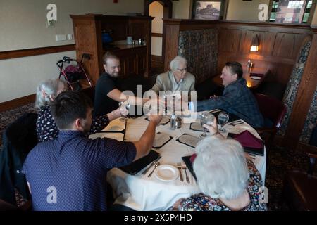 Feierliches Abendessen mit drei Generationen von Familien, die mit wassergefüllten Gläsern im Midland Hills Country Club getoast werden. St. Paul Minnesota MN USA Stockfoto
