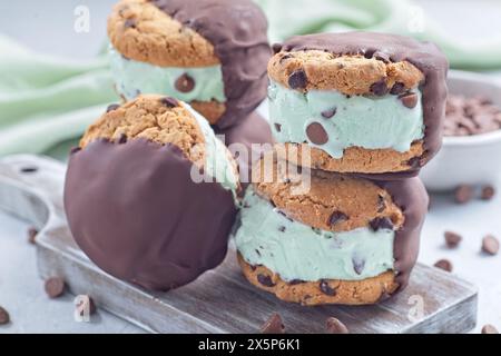 Stapel mit Eis-Sandwiches mit dunkler Schokolade, Minzschokolade-Chips Eis und Schokoladen-Chips-Kekse, auf Holzbrett, horizontal, Nahaufnahme Stockfoto