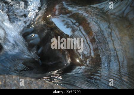 Nahaufnahme eines Gebirgswasserstroms, der die Felsen hinunter fließt Stockfoto