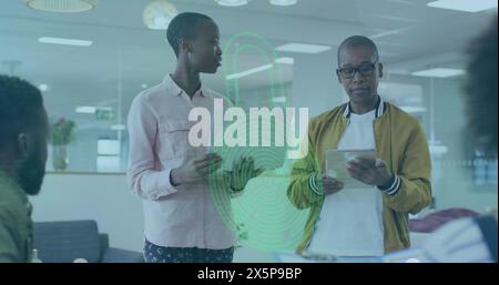 Eine Gruppe afroamerikanischer Kollegen diskutiert, eine hält eine Tablette Stockfoto