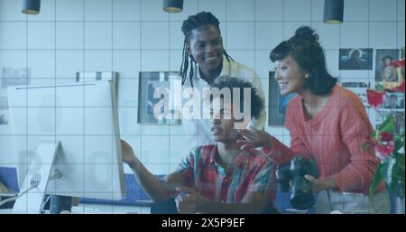 Ein vielfältiges Team arbeitet zusammen und betrachtet den Computerbildschirm Stockfoto