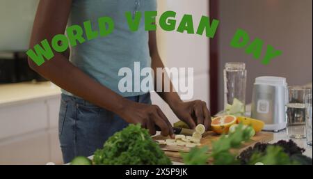 Bild des veganen Welttagstextes über afroamerikanerin, die Gemüse schneidet Stockfoto