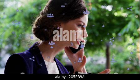 Bild von Symbolen, die mit Linien über der kaukasischen Frau verbunden sind, die auf dem Smartphone spricht Stockfoto