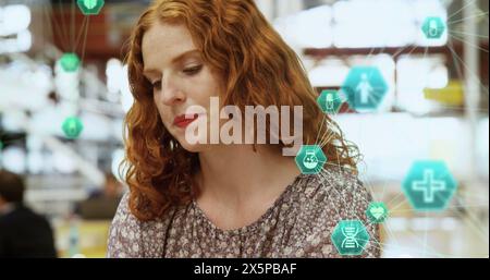 Bild von vernetzten Ikonen, die Kugeln über der kaukasischen Frau bilden, die auf dem Smartphone spricht Stockfoto