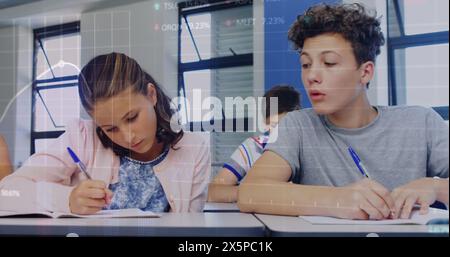 In der Schule schreibt ein weißes Mädchen/Freund, ein birassischer Junge/Freund schaut beiseite Stockfoto