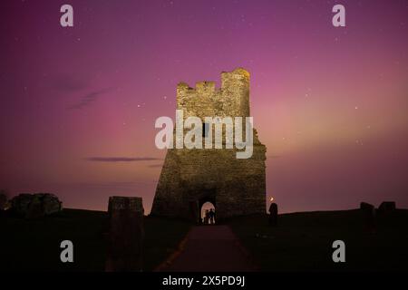 Aberystwyth, Ceredigion, Wales, Vereinigtes Königreich. 10. Mai 2024 Wetter in Großbritannien: Ein Blick auf die Ruinen von Aberystwyth Castle und eine spektakuläre Show der Aurora Borealis, auch bekannt als die Nordlichter, wie sie heute Abend in Aberystwyth, Wales, zu sehen sind. © Ian Jones/Alamy Live News Stockfoto