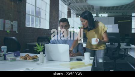 Kaukasischer Mann und birassische Frau arbeiten im Büro am Computer Stockfoto