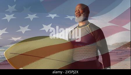 Bild der Flagge der usa über einem ranghohen afroamerikaner mit Surfbrett am Strand Stockfoto