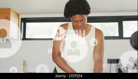 Bild mehrerer Profilsymbole über afroamerikanischen Athleten, die zu Hause Obst in der Küche schneiden Stockfoto