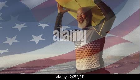 Bild der Flagge der usa über einem glücklichen älteren afroamerikaner mit Surfbrett am Strand Stockfoto