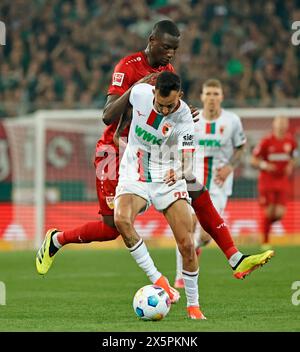 Augsburg, Deutschland. Mai 2024. Iago Amaral Borduchi (Front) von Augsburg streitet mit Serhou Guirassy von Stuttgart beim Fußball-Spiel der ersten Bundesliga zwischen dem FC Augsburg und dem VfB Stuttgart am 10. Mai 2024 in Augsburg. Quelle: Philippe Ruiz/Xinhua/Alamy Live News Stockfoto