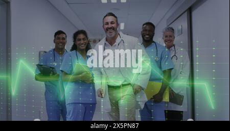 Bild des Herzfrequenzmessgeräts über einem Team von verschiedenen Ärzten und Gesundheitspersonal, die im Krankenhaus lächeln Stockfoto