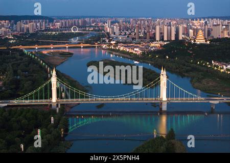 Peking, China. Mai 2024. Ein Luftbild der Drohne, aufgenommen am 9. Mai 2024, zeigt einen nächtlichen Blick entlang des Weihe-Flusses in Baoji, der nordwestlichen chinesischen Provinz Shaanxi. Baoji in der nordwestlichen chinesischen Provinz Shaanxi am Fuße des Qinling-Gebirges und entlang des Weihe-Flusses hat sich weiterhin bemüht, eine lebenswerte städtische Umgebung zu schaffen. In den letzten Jahren wurden insgesamt 36 kleine Stadtparks errichtet, die den Bürgern Freiräume für Freizeit und Sport bieten und die ökologische Umwelt der Stadt verbessern. Quelle: Shao Rui/Xinhua/Alamy Live News Stockfoto