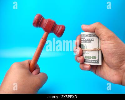 Handheld Hamel und Banknoten auf blauem Hintergrund. Stockfoto