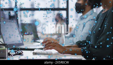 Verschiedene Freunde, die an Notebooks arbeiten, umgeben von Grafikblasen Stockfoto