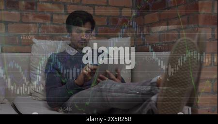 Bild von mehreren Diagrammen und Zahlen über kaukasier, der sich auf der Couch entspannt und das Handy benutzt Stockfoto