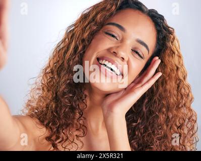 Schönheit, Haare und Selfie mit einem Lächeln der Frau im Studio auf grauem Hintergrund für natürliche oder Shampoo-Behandlung. Porträt, Hautpflege und Wellness mit Happy Stockfoto