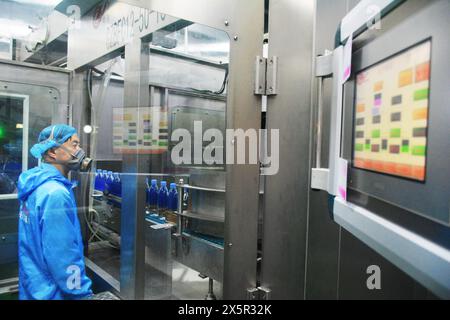 ANQING, CHINA - 11. MAI 2024 - Ein Arbeiter arbeitet an einer Flaschenwasserproduktionslinie in einer Werkstatt eines Getränkeherstellers in der Stadt Anqing, Ostchinas Stockfoto