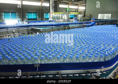 ANQING, CHINA - 11. MAI 2024 - Ein Arbeiter arbeitet an einer Flaschenwasserproduktionslinie in einer Werkstatt eines Getränkeherstellers in der Stadt Anqing, Ostchinas Stockfoto