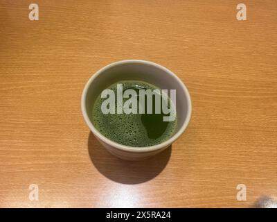 Grüner Matcha-Tee in einer Tasse auf dem Holztisch zum Trinken Stockfoto