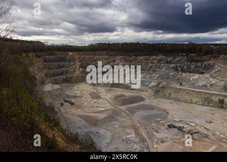 Sandsteinbruch mit Baggerausrüstung unter dramatischem Himmel. Hintergrund der Grabindustrie, tschechische Landschaft Stockfoto