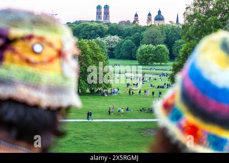 Blick vom Monopteros auf den Englischen Garten, kurz vor Sonnenuntergang, Wochenende, München, Mai 2024 Deutschland, München, Mai 2024, Blick vom Monopteros auf den Englischen Garten, Blaue Stunde kurz vor Sonnenuntergang, viele Menschen genießen den Frühlingsabend, zwei Touristinnen mit bunten Hüten schauen auf die Münchner Stadtsilhouette mit Frauenkirche und Theatinerkirche, Freitagabend, Bayern, *** Blick vom Monopteros zum Englischen Garten, kurz vor Sonnenuntergang, Wochenende, München, Mai 2024 Deutschland, München, Mai 2024, Blick von den Monopteros zum Englischen Garten, blaue Stunde kurz bef Stockfoto