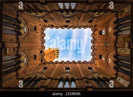 Blauer Himmel durch den Innenhof des Rathauses (Palazzo Pubblico) und den Turm von Mangia (Torre del Mangia). Foto am 23. Oktober 2023 in Stockfoto