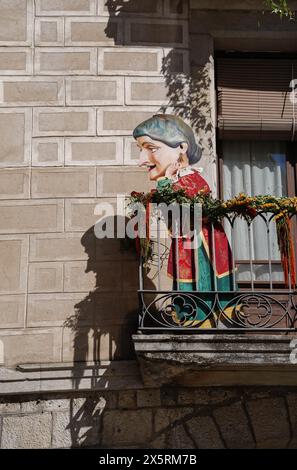 Eine riesige alte Frau wird auf einem Balkon beim Girona Blumenfest gemalt. Temps de Flors 2024 Stockfoto