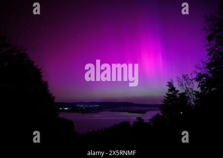 Kochel Am See, Deutschland. Mai 2024. Nordlichter (aurora borealis) flackern am Nachthimmel über dem Kochelsee bei Kochel am See (Bayern) am 11. Mai 2024. Quelle: Matthias Balk/dpa/Alamy Live News Stockfoto