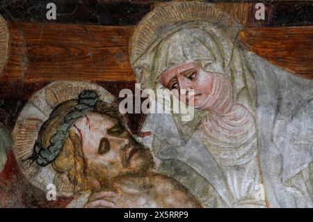 Maria mit dem Leichnam ihres gekreuzigten Sohnes. Detail aus dem Fresko im Kreuzgang aus dem 12. Jahrhundert neben dem Dom Santa Maria Assunta (Kathedrale der Heiligen Maria der Himmelfahrt) in Brixen-Brixen in Südtirol, Trentino-Südtirol, Italien. Stockfoto