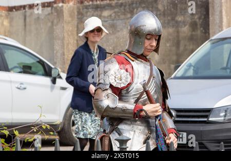 Frau in mittelalterlicher Rüstung als Mitglied der Suffolk Knights-Nachstellung-Gruppe, die in einer modernen Umgebung etwas seltsam aussieht Stockfoto