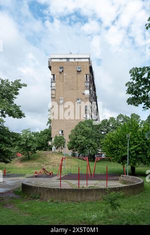 Brutalistische Architektur in Belgrad mit einem gemeinschaftlichen Erholungspark davor. Mai 2024. Stockfoto