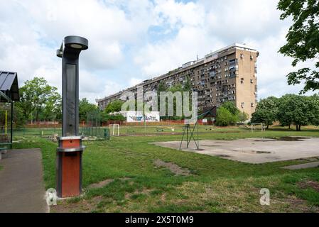 Brutalistische Architektur in Belgrad mit einem gemeinschaftlichen Erholungspark davor. Mai 2024. Stockfoto