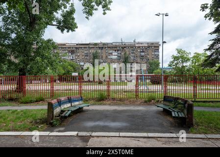 Brutalistische Architektur in Belgrad mit einem gemeinschaftlichen Erholungspark davor. Mai 2024. Stockfoto