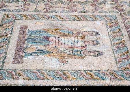 Das Drei-Horae-Mosaik. Dieser zentrale Mosaikboden zeigt die drei Horae auf weißem Hintergrund durch eine Oberleitungszone. Archäologischer Park Paphos. Stockfoto