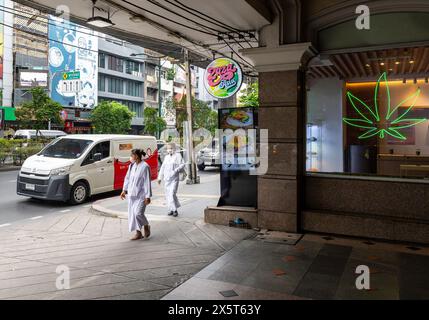 Bangkok, Thailand. Mai 2024. Mönchsfrauen werden vor der ZaZa Asia Cannabis-Apotheke und dem Unkrautladen an der Sukhumvit Road in Bangkok gesehen. Thailands Premierministerin Srettha Thavisin will Cannabis bis zum Jahresende als Betäubungsmittel umklassifizieren und seine Entkriminalisierung vor zwei Jahren rückgängig machen. Seit der Entkriminalisierung im Juni 2022 ist die thailändische Marihuana-Industrie mit Tausenden von Ausgabestellen und ausländischen Investitionen in High-Tech-Cannabisfarmen rasant gewachsen. Quelle: SOPA Images Limited/Alamy Live News Stockfoto