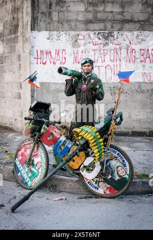 Ein philippinischer Mann, der in Angeles City lebt, hat dieses Fahrrad mit gefälschter Militärrüstung personalisiert. Ich denke, es könnte eine politische Botschaft in seinen Zielen geben. Stockfoto