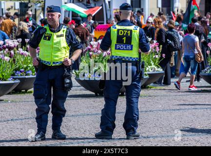 Malmö, Schweden. Mai 2024. 11. Mai 2024, Schweden, Malmö: Polizeibeamte sichern Protest gegen die Teilnahme Israels am Finale des Eurovision Song Contests (ESC) 2024 im Stadtzentrum. Dieses Jahr wird das bunte Musikfestival vom Gaza-Krieg überschattet, die Polizei ist in Alarmbereitschaft und hält die Sicherheitsmaßnahmen hoch. Im weltweit größten Gesangswettbewerb unter dem Motto „United by Music“ treten 26 Länder im Finale gegeneinander an. Foto: Jens Büttner/dpa Credit: dpa Picture Alliance/Alamy Live News Stockfoto