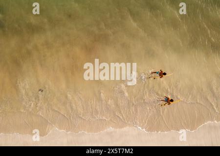 Indonesien, Lombok, aus der Vogelperspektive von Surfern, die im Meer spazieren Stockfoto