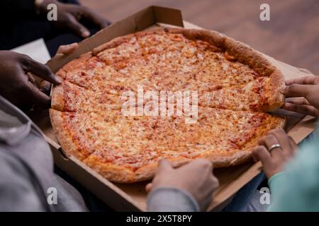Gruppe von Freunden Pizza essen Stockfoto