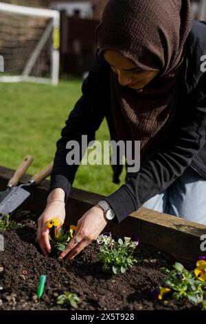 Frau kümmert sich um Blumen im Garten Stockfoto