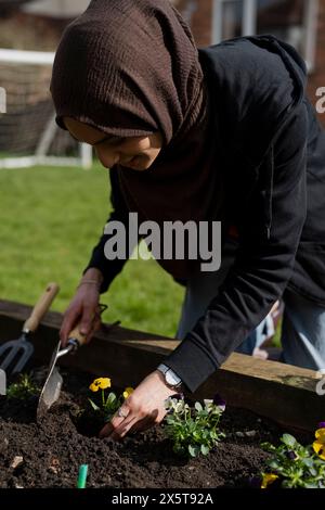 Frau kümmert sich um Blumen im Garten Stockfoto