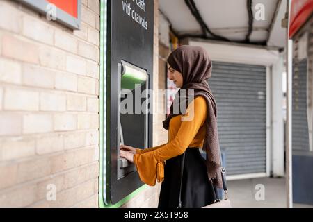 Frau im Hijab mit Geldautomat Stockfoto