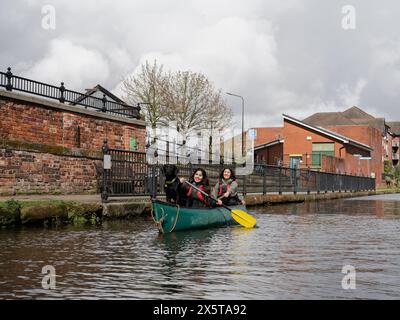 Frauen und Hunde Kanufahren im Kanal Stockfoto