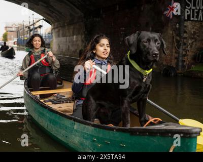 Frauen und Hunde Kanufahren im Kanal Stockfoto