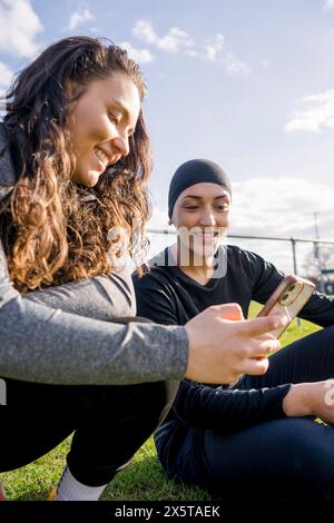 Fußballspielerinnen, die während der Pause telefonieren Stockfoto