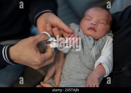 Eltern trimmen Nägel für Babys Töchter (0-1 Monate) Stockfoto